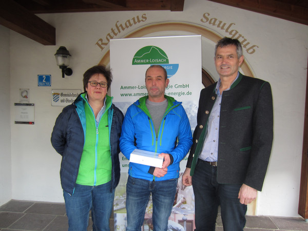 Drei Personen bei der Gewinnübergabe eines Tablets an einen Kunden der Ammer-Loisach Energie.